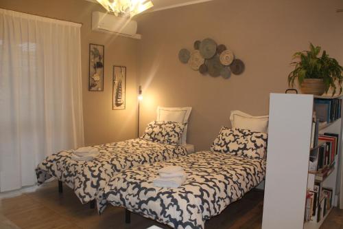 a bedroom with two beds and a plant at La Casetta 2 -10 min Aeroporto e spiaggia in Fiumicino