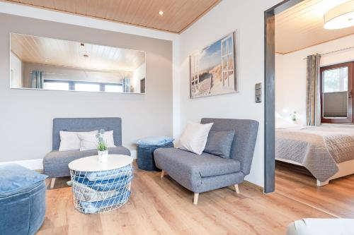 a living room with a bed and a couch and a chair at Haus Schwanensee Seezauber in Bosau