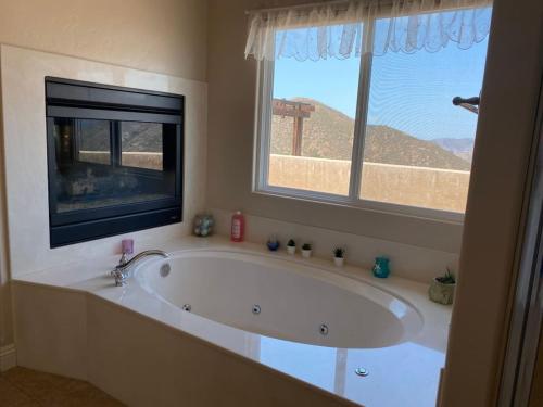 een groot bad in een badkamer met een raam bij Acres of Bliss - A hillside getaway in Ramona