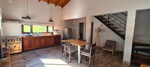 kuchnia z drewnianym stołem i schodami w obiekcie Las Piedritas Cafayate w mieście Cafayate