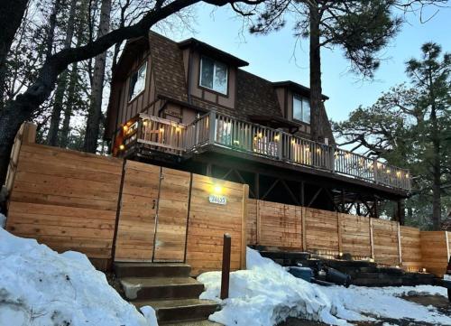 a house in the trees with snow on the ground at Blissfully Wild -with Hot Tub and pets are welcome in Idyllwild