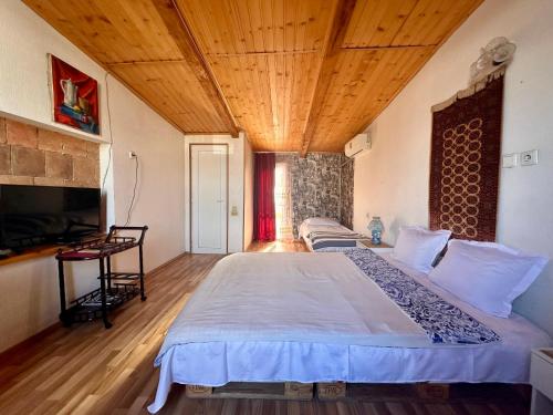 a bedroom with a large bed with a wooden ceiling at Heart of Old Tbilisi Apartments in Tbilisi City