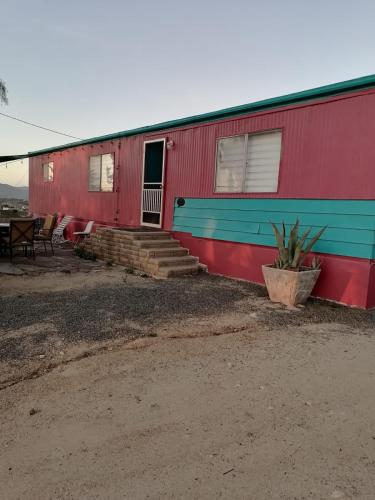 a red and blue building with stairs and a table at Rancho Matalote en Valle de Guadalupe in Valle de Guadalupe