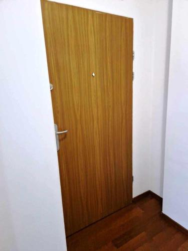 a wooden door in a room with a wooden floor at Great Apart Kabaty in Warsaw