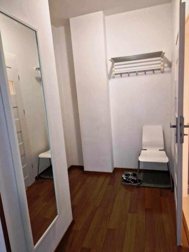 a room with a white chair and a mirror at Great Apart Kabaty in Warsaw