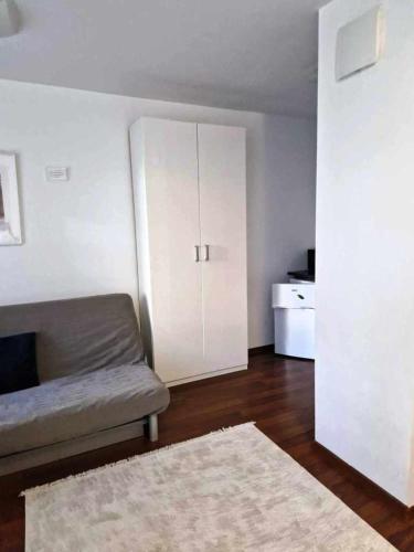 a living room with a couch and a white cabinet at Great Apart Kabaty in Warsaw