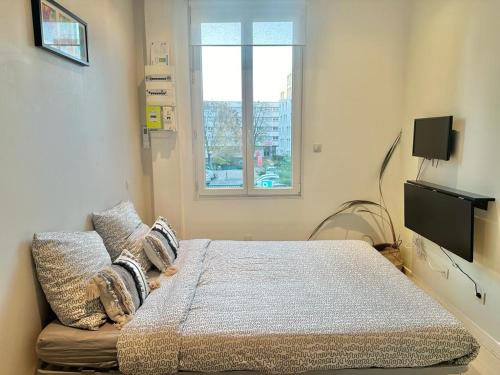 sypialnia z łóżkiem, kanapą i oknem w obiekcie Gaby, cosy & cocooning, idéal pour 2pers w mieście Villeurbanne