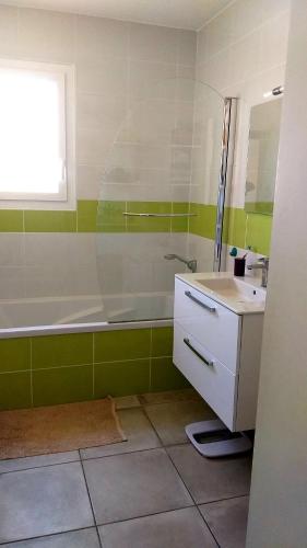 une salle de bain avec une baignoire et un lavabo dans l'établissement Chambre dans maison, près de la mer, de l'Espagne, des Montagnes, à Pézilla-la-Rivière