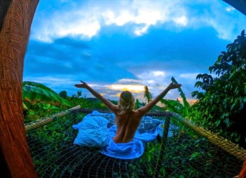 a woman in a blue dress laying on a net at Monte Mágico in Támesis