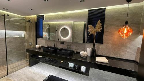a bathroom with two sinks and a large mirror at Apartman Emel in Bodrum City