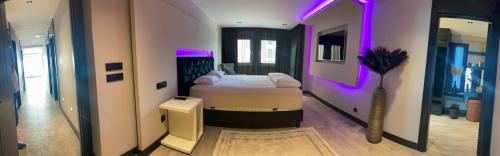 a bedroom with a bed with purple lights on it at Apartman Emel in Bodrum City