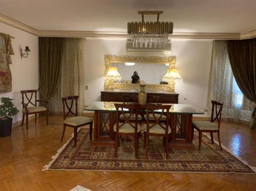 een eetkamer met een tafel en een spiegel bij Luxury Apartment Nasr City in Caïro