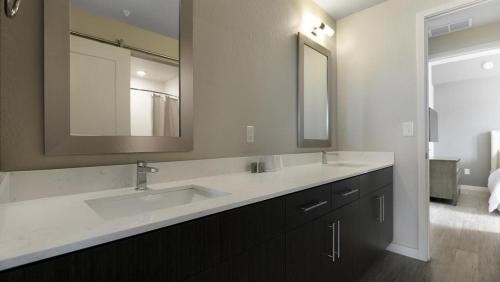 uma casa de banho com 2 lavatórios e um espelho grande em Landing Modern Apartment with Amazing Amenities (ID8608X81) em Fort Myers Villas