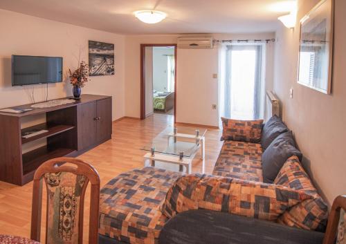 salon z kanapą i telewizorem w obiekcie Apartments Grzin w mieście Mošćenička Draga