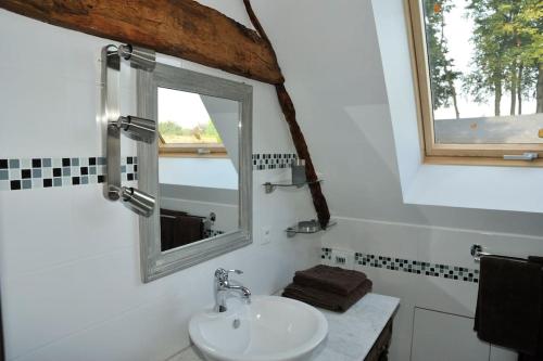 une salle de bain avec un lavabo et une fenêtre dans l'établissement demeure de caractère avec cheminée, à Houdetot