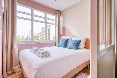 Schlafzimmer mit einem weißen Bett und einem Fenster in der Unterkunft Appartement proche Parc Monceau / Pereire - II in Paris