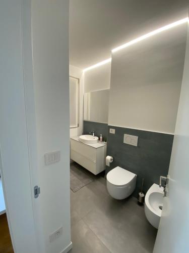 a bathroom with two toilets and a sink and a mirror at HZ+ Costantini in Pordenone
