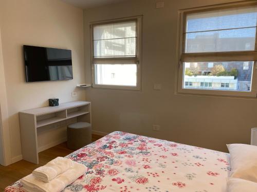 a bedroom with a bed and a tv and a window at HZ+ Costantini in Pordenone