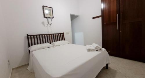 a bedroom with a white bed and a wooden cabinet at Villa Alba in Natal