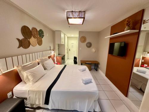 a bedroom with a large bed and a television at Gran Lençóis Flat Barreirinhas APT 510 in Barreirinhas