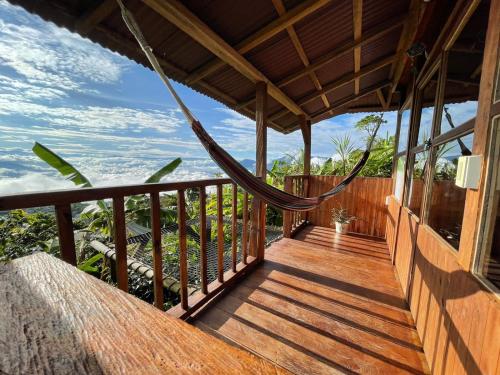 a porch of a house with a hammock on it at Monte Mágico in Támesis