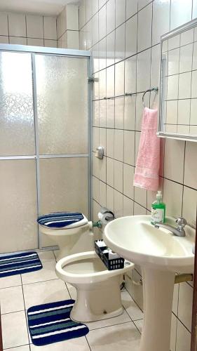 a bathroom with a shower and a toilet and a sink at Quarto privativo in Balneário Camboriú