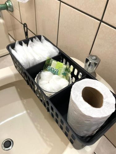 a basket of toilet paper sitting on a bathroom sink at Quarto privativo in Balneário Camboriú