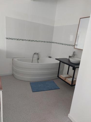 Baño blanco con bañera y lavamanos en Le Liyann, en Saint-Pierre