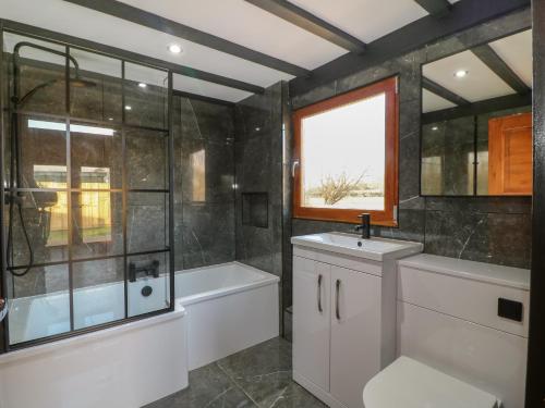 a bathroom with a tub and a toilet and a sink at Squirrel's Nest in Oakham