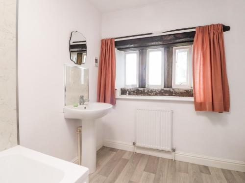 a bathroom with a sink and a window at Boothsteads Farm Cottage in Halifax