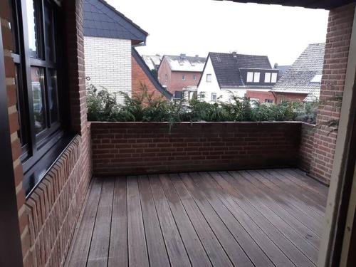 a balcony with a brick wall and a wooden deck at Wohnung in Greven in Greven