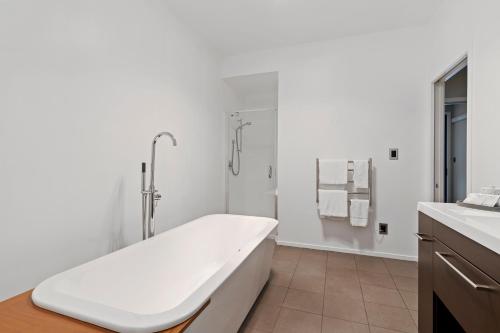 a white bathroom with a tub and a shower at Waterfront Lake Hood Luxury in Wakanui