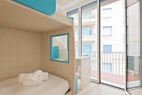 ein Schlafzimmer mit einem Bett und einem großen Fenster in der Unterkunft TRENDY APARTMENT CLOSE to the beach in Albissola Marina