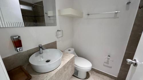 a bathroom with a sink and a toilet and a mirror at Suites Casa Blanca in La Paz