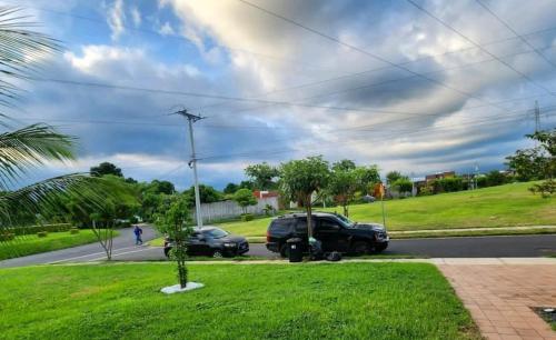 um par de carros estacionados ao lado de uma rua em Marhabi's home em Sonsonate