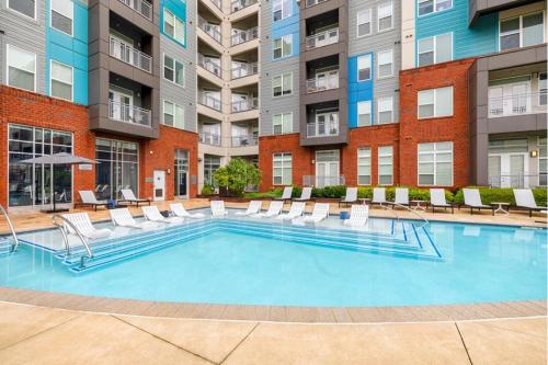 a large swimming pool with chairs and a building at Luxury 2-Bed 2 Bath Apartment in King of Prussia