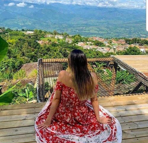 a woman in a red dress sitting on a deck at Monte Mágico in Támesis