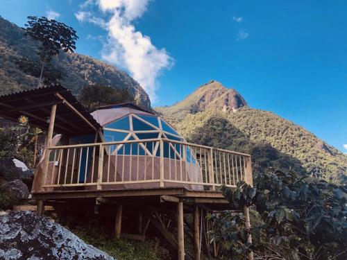 a house on a wooden platform with mountains in the background at Monte Mágico in Támesis