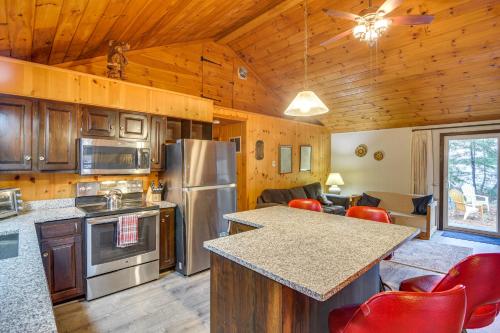 a kitchen and living room in a log cabin at Cozy Thompson Lake Cabin with Boat Dock and Launch in Dunkertown