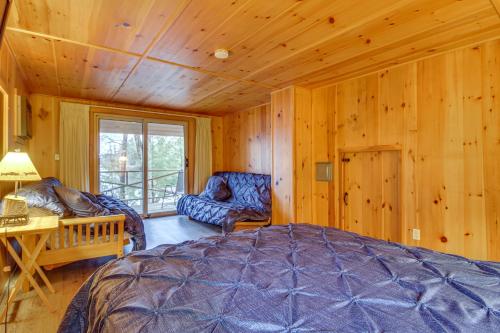 a bedroom with a bed and a chair in a room at Cozy Thompson Lake Cabin with Boat Dock and Launch 