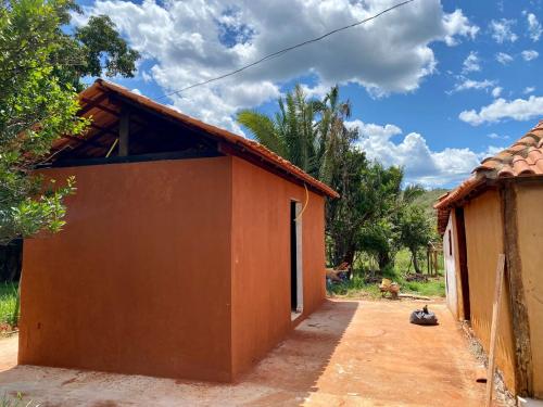 um edifício laranja com um gato sentado ao seu lado em Espaço Amainar em Sobradinho