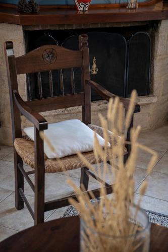 a wooden chair with a pillow on it in front of a fireplace at Earino in Kato Asites