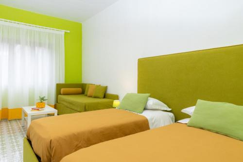um quarto de hotel com duas camas e um sofá em Sunny Flat free parking em Sorrento