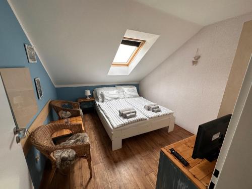 ein kleines Schlafzimmer im Dachgeschoss mit einem Bett und einem Fenster in der Unterkunft Penzion Na Zelnicách in Ratíškovice