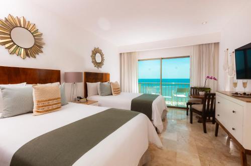 Villa Premiere Boutique Hotel & Romantic Getaway - Adults Only في بويرتو فايارتا: سريرين في غرفة الفندق مطلة على المحيط