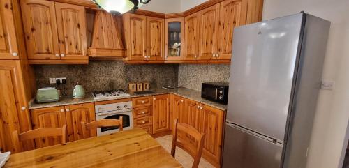 a kitchen with wooden cabinets and a stainless steel refrigerator at Ramla Boutique Home in Marsaskala