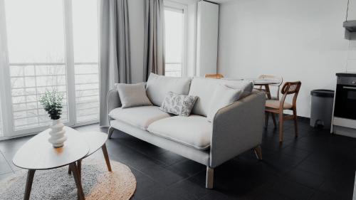 a living room with a white couch and a table at Studio Saint-Martin in Tournai
