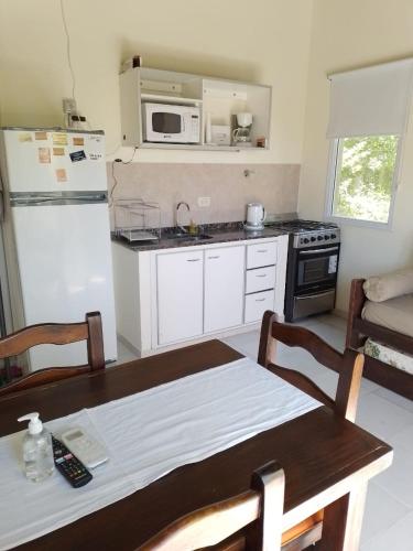 a kitchen with a table and a kitchen with a microwave at Princesas Del Mar a 4 cuadras del mar in Mar Azul