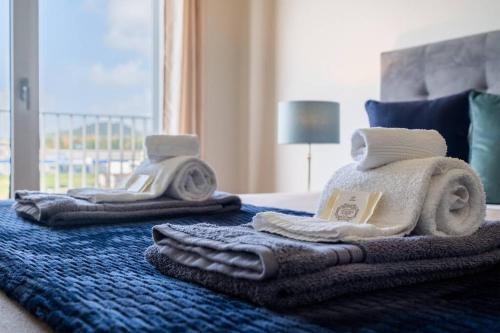 a bedroom with towels on a bed with a window at Quiet & Comfy Azorean Sapphire in Fajã de Baixo
