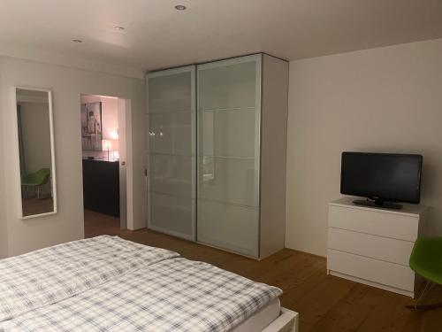 a bedroom with a bed and a television in it at Tritt ein bring Glück herein - Exquisite 75 qm - Messenähe - Parkplatz - Flughafennähe in Düsseldorf